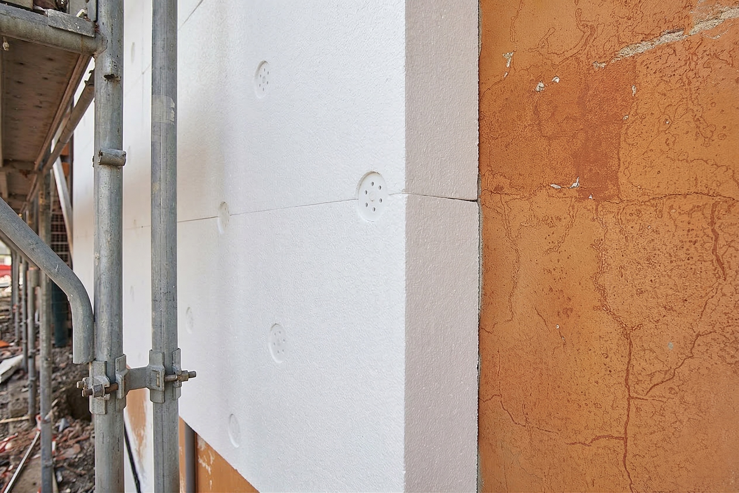 Installation of EPS insulation boards on exterior wall using mechanical anchors in an ETICS system