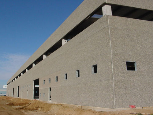 Modern industrial building facade using integrated decorative insulation panels with grey sand-textured finish